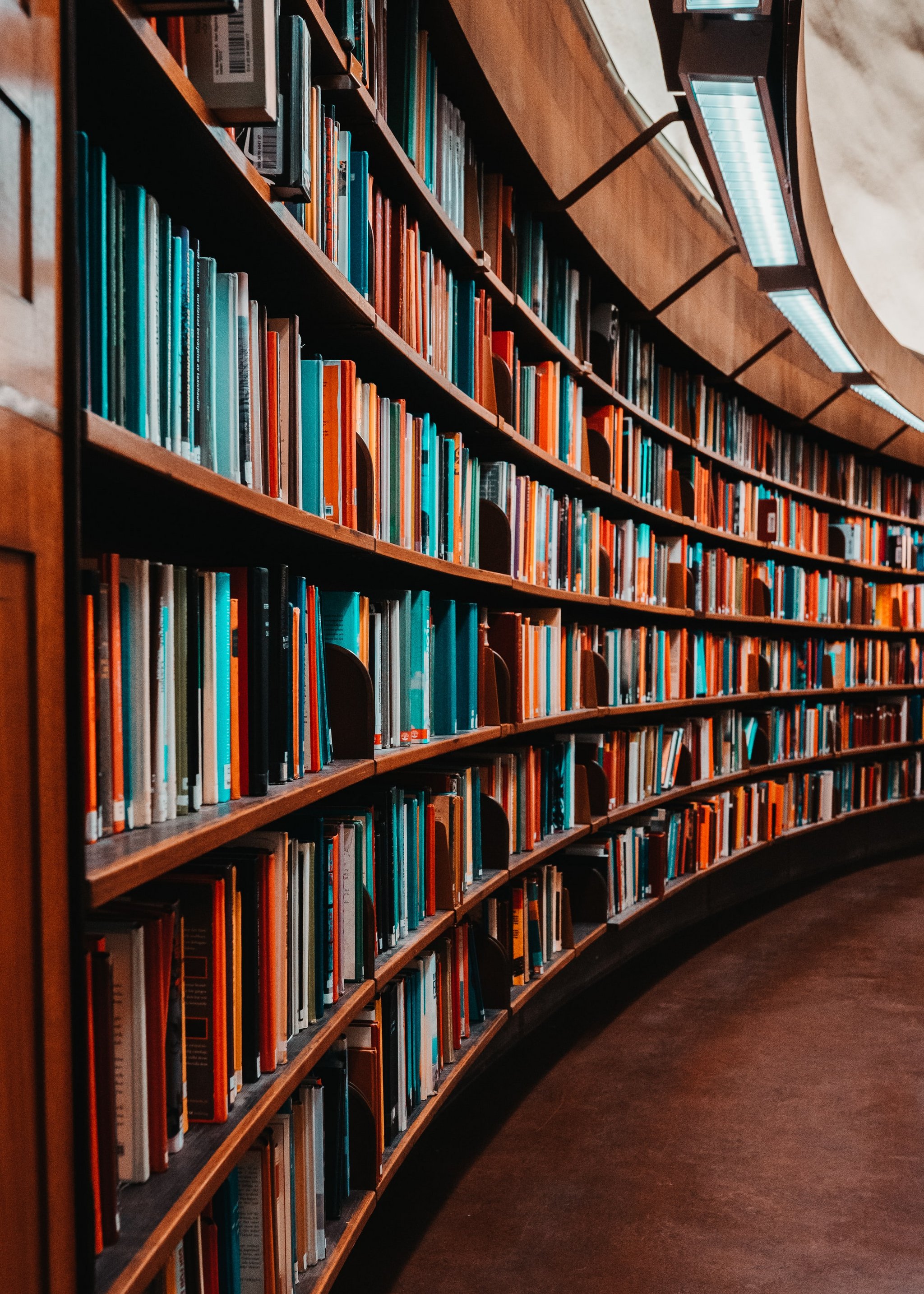 Das Bild zeigt Regalreihen mit Büchern in einer Bibliothek