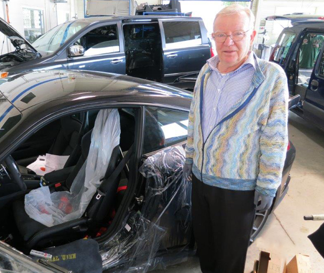 Das Bild zeigt Eberhard Franz vor einer Autokarosserie